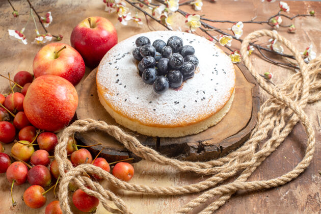 食物水果一个开胃的蛋糕 桌上有葡萄 三个苹果和浆果蓝莓健康甜点