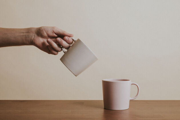 手手拿陶瓷咖啡杯杯子木桌茶