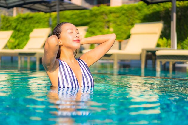 水疗肖像美丽的年轻女子放松微笑休闲度假酒店游泳池周围休闲健康豪华