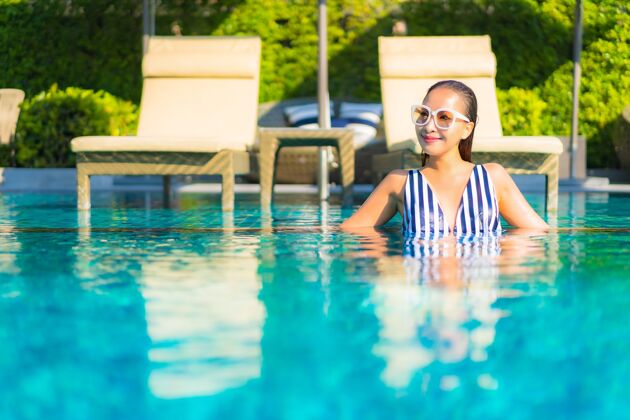 身体肖像美丽的年轻女子放松微笑休闲度假酒店游泳池周围酒店享受女士
