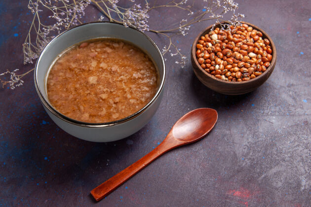 勺子顶视图褐色的汤面上有黑豆汤菜饭菜菜豆晚餐胡椒餐