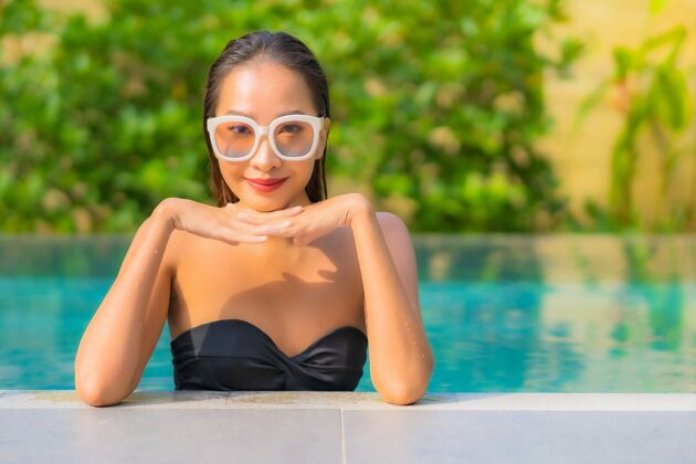 阳光美丽的亚洲年轻女子在游泳池里放松的画像美丽假日放松