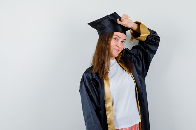 女孩女毕业生穿着制服 手放在头上 穿着休闲服 看起来很迷人正面图证书大学欢呼