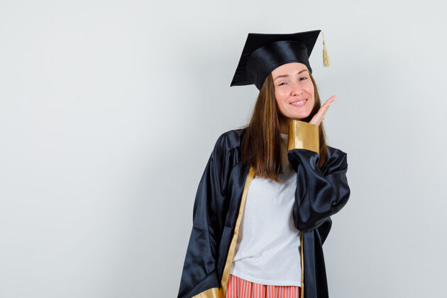 肖像毕业的女人穿着休闲服 手贴着脸摆姿势 穿着制服 看起来很精致前视图妇女制服衣服