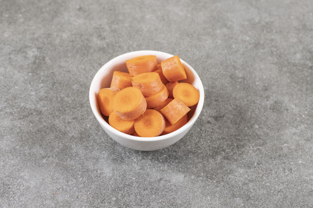 蔬菜在大理石表面放一碗新鲜的胡萝卜片天然营养新鲜