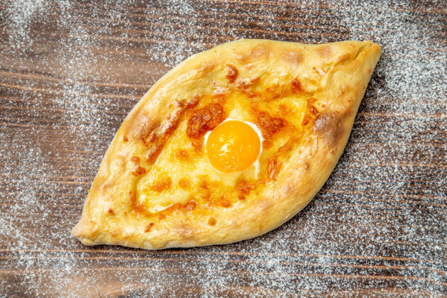 面包顶视图新鲜的烤面包和煮熟的鸡蛋放在棕色的桌子上面团食物烤面包和鸡蛋面团顶部面包