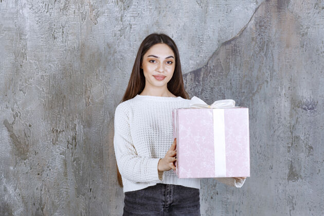 礼物女人手里拿着一个用白丝带包着的紫色礼盒礼盒成人女人