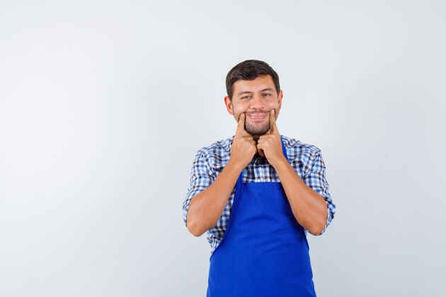 制服穿着蓝色围裙和衬衫的年轻男厨师年轻男士烹饪
