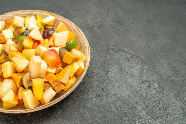美味水果沙拉正面图美味的水果沙拉由新鲜水果组成 灰色的桌子上有很多新鲜水果晚餐盘子饮食