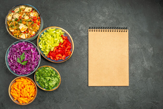 深色顶视图不同的蔬菜切片与鸡肉沙拉在黑暗的餐桌上健康沙拉饮食正餐乐队饮食