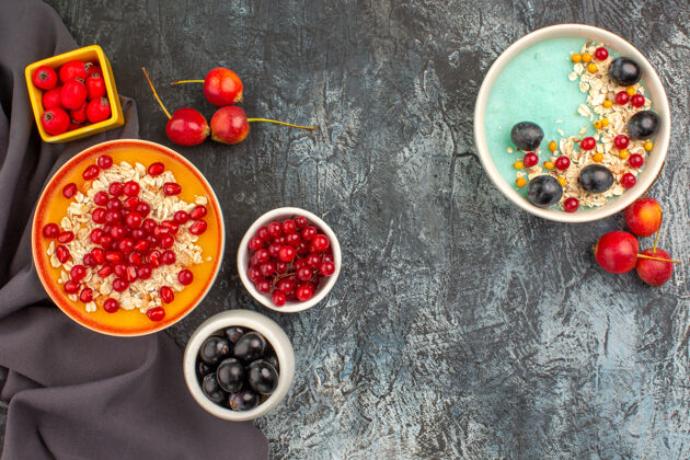 碗浆果燕麦片石榴浆果在深色桌布上的俯视图食物美味浆果