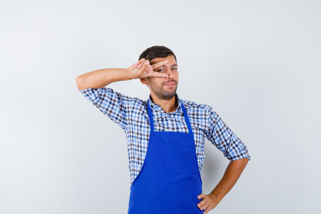 衬衫穿着蓝色围裙和衬衫的年轻男厨师年轻烹饪男士