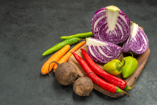 健康前视图新鲜的红色卷心菜与其他蔬菜在黑暗的桌子上饮食熟沙拉健康新鲜的红色卷心菜蔬菜胡椒