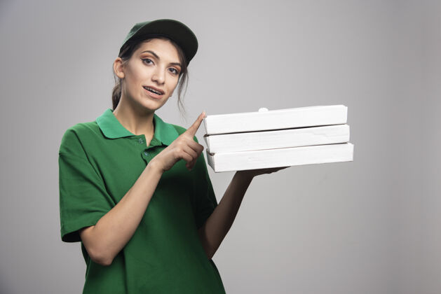 工作女信使摆出披萨盒的姿势食物制服披萨