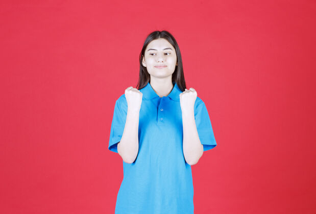 快乐穿蓝色衬衫的女人站在那里 手上显示积极的手势成年人满意女人