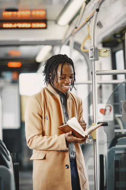 棕色一个非洲裔美国人坐在城市公共汽车上一个穿棕色外套的人一个拿着笔记本的人商人旅行持有