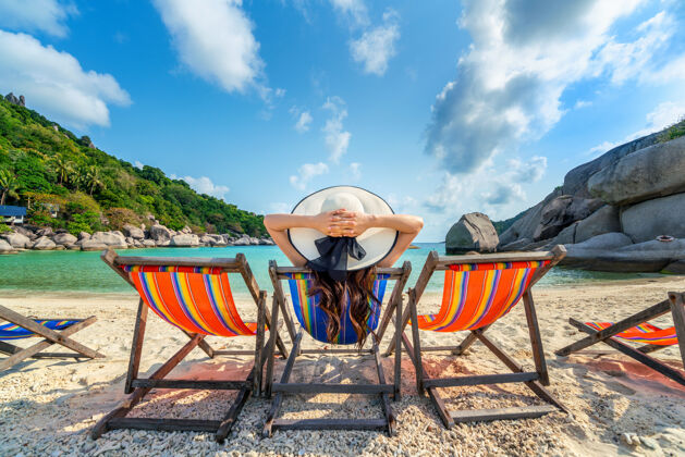 海洋戴着帽子的女人坐在美丽的热带海滩的椅子上在南苑岛的热带海滩上放松的女人亚洲坐着沙滩