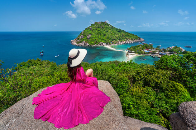 热带美丽的女孩坐在观景湖南苑岛附近的岛 泰国素拉特萨伊岛服饰岩石度假