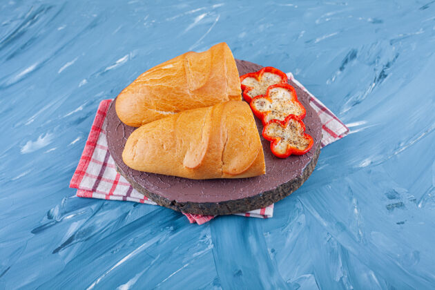 胡椒新鲜的白面包片放在木片和胡椒片上奶酪桌布切