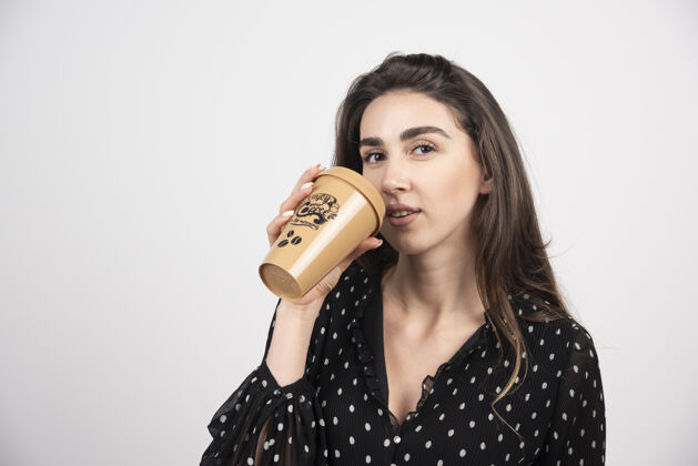 表达年轻的女模特用咖啡杯喝酒成人模特年轻人