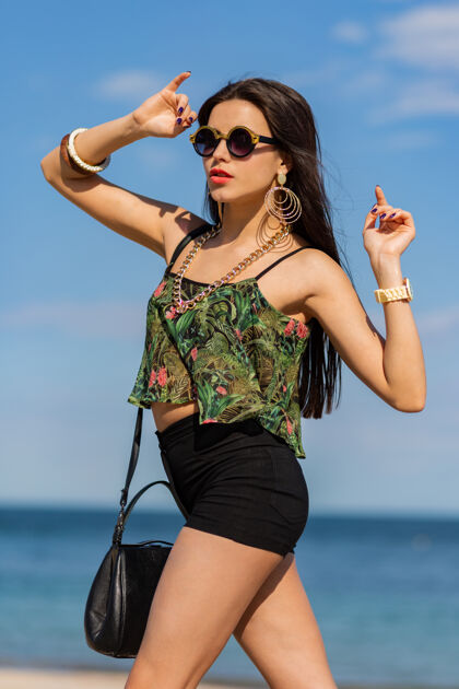 心情时尚的黑发女孩穿着时尚的夏季服装在沙滩上散步模特自然度假