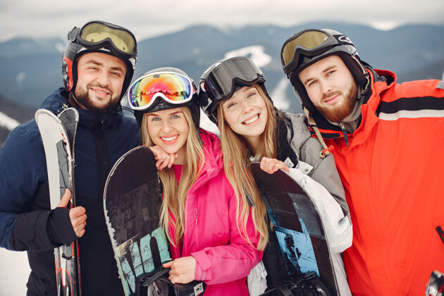 朋友穿着滑雪板套装的朋友在山上玩滑雪板的人在地平线上手拿滑雪板的人关于运动的概念滑雪板护目镜人