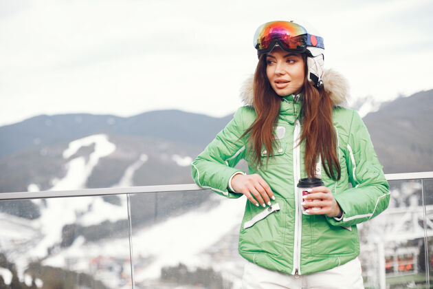 冬天冬天山上的女人穿着滑雪服的女人杯子白天山