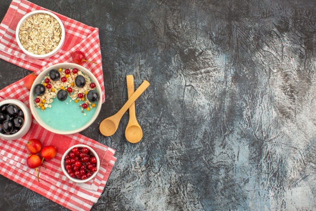 五颜六色浆果顶视图一碗五颜六色的浆果燕麦樱桃勺子放在桌布上复制空间燕麦片浆果