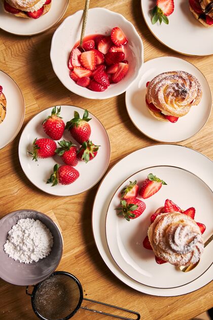 早餐头顶拍摄美味的奶油泡芙与草莓和巧克力在木桌上糖泡芙巧克力