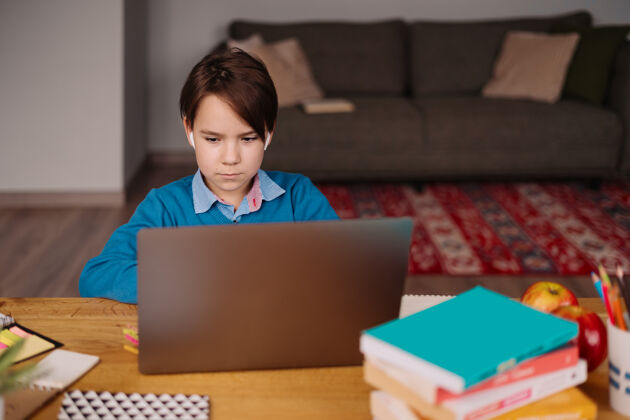 沟通一个未成年男孩用笔记本电脑在线上课学习社会距离房子