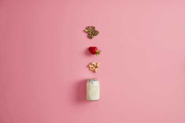 划船一罐新鲜酸奶和原料 如南瓜子 成熟开胃草莓 腰果自制营养甜点节食和超级食品概念早餐美味的想法从上面看种子玻璃干燥