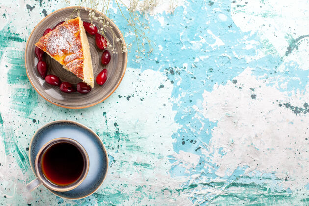 新鲜顶视图蛋糕片新鲜的红山茱萸和一杯茶蓝色背景水果蛋糕烤派糖饼干甜咖啡蛋糕杯子