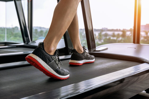 运动服穿着运动鞋在健身房跑步机上跑步的男性脚运动概念健康跑步机身体