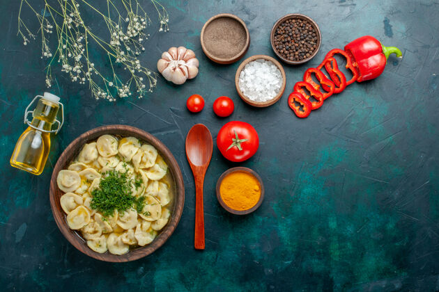 蔬菜俯瞰美味的饺子汤与油调味料和西红柿绿色背景食物餐汤面团肉美食盘子午餐