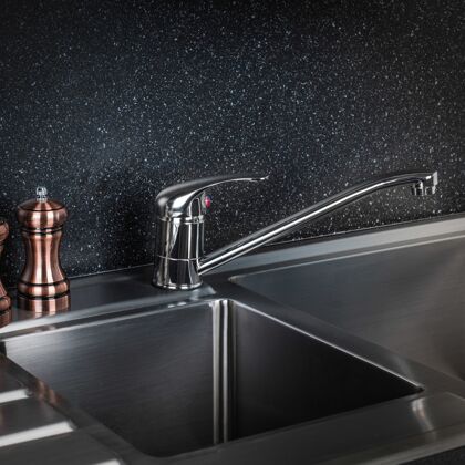 家庭新的和现代的钢水龙头在厨房里浴室水水流