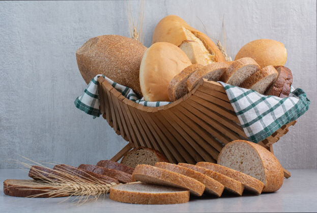 篮子各式各样的面包放在大理石表面的篮子里面包美味切片