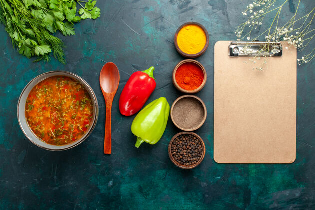 饮食俯瞰美味的蔬菜汤与不同的调味料和记事本上深绿色的表面食物餐蔬菜配料汤产品顶部不同的胡椒