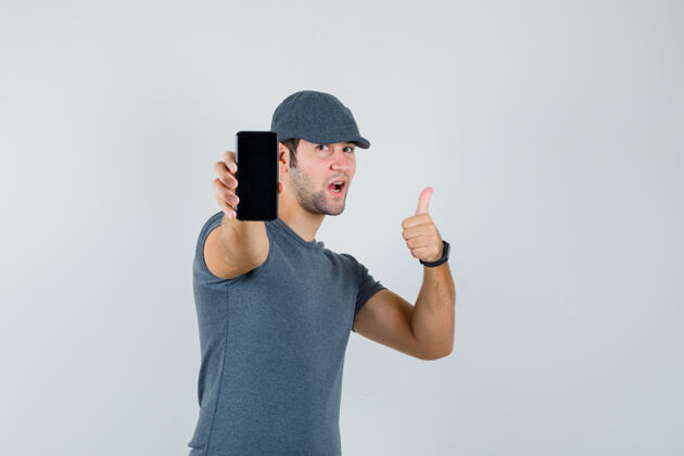 幼儿戴着t恤帽拿着手机的年轻男子竖起大拇指抱着男孩男性