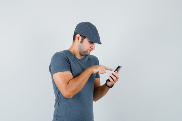 虚拟年轻男子戴着t恤帽用手机 看上去很忙幼儿电话衬衫