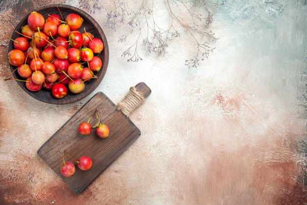 可食用水果顶部特写查看樱桃木砧板碗里的樱桃树枝新鲜樱桃健康
