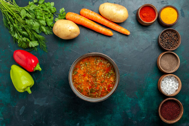 胡萝卜俯瞰美味的蔬菜汤与不同调味料的深绿色表面食物餐蔬菜配料汤产品生的美食不同