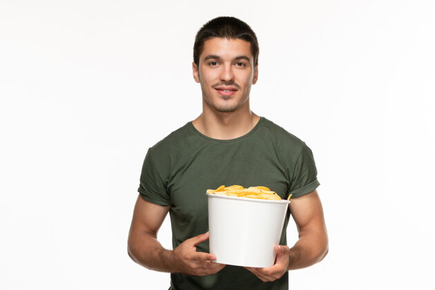 咖啡正面图身着绿色t恤的年轻男子拿着篮子 白色背景上放着土豆 孤独地享受电影电影院电影篮子年轻男性