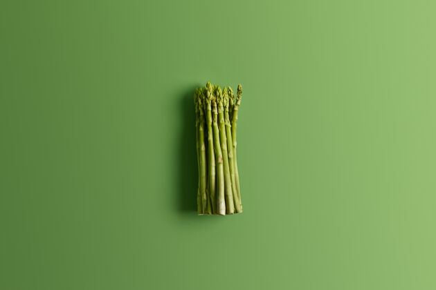 明亮一束鲜芦笋 鲜艳的绿色背景制作美味的素食沙拉的原料食物概念新鲜的春季蔬菜富含维生素 叶酸的芦笋芽捆绑饮食配料