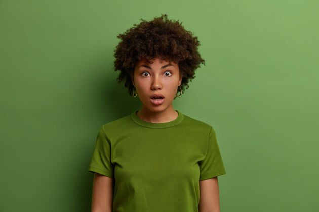 非洲年轻情绪激动的黑皮肤女人意识到发生了什么坏事 目睹了可怕的事故 垂头丧气 听到可怕的消息 站在绿色的墙壁上 穿着随意恐惧非洲喘息
