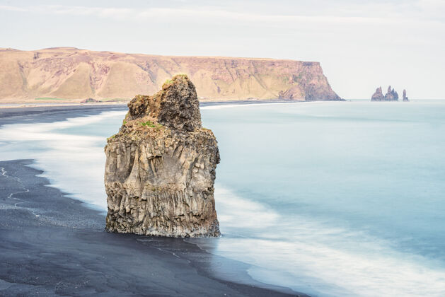 训练拍摄一个大岩石在海中 雷尼斯菲亚拉海滩在维克 冰岛圆柱海岸沙子