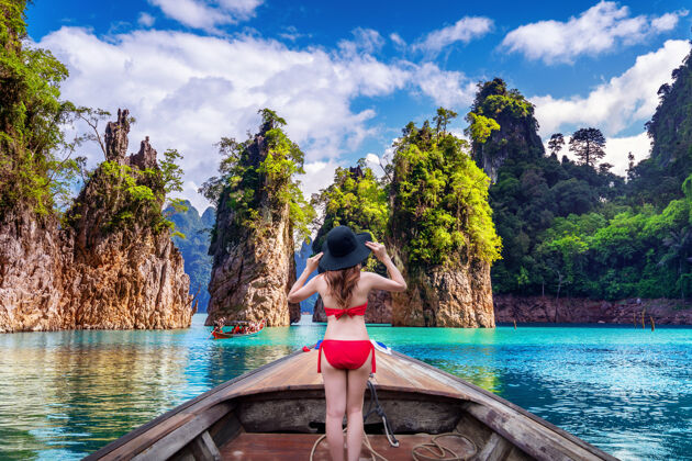 娱乐泰国素拉特萨尼省考索国家公园 美丽的女孩站在船上望着ratchaprapha大坝的群山热带岩石船
