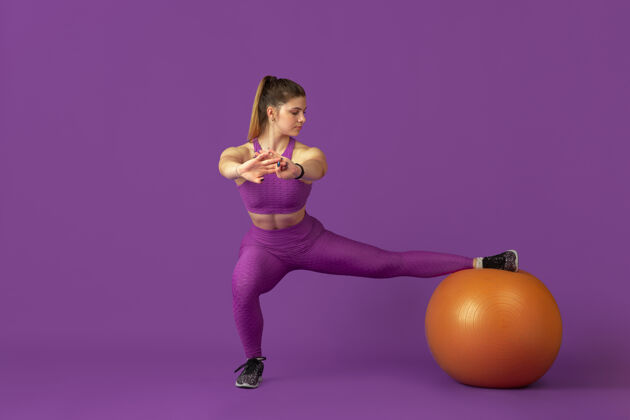 杠铃外形美丽的年轻女运动员在工作室练习 单色紫色肖像健身交叉训练