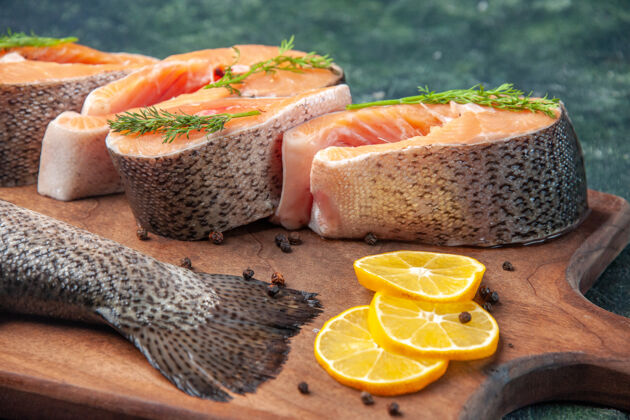木材高分辨率的照片新鲜的生鱼片柠檬片青椒木砧板上的深色混合色表生鱼深色膳食