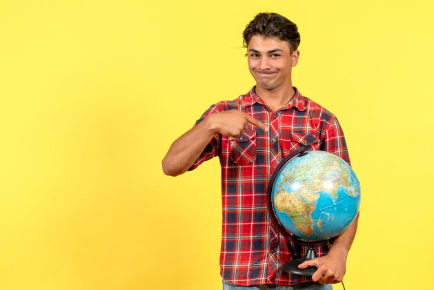 球正面图年轻男性手持地球仪 背景为黄色男模颜色成人举行体育