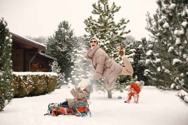 童年女人和小女孩在公园里玩雪橇太阳镜自然衣服